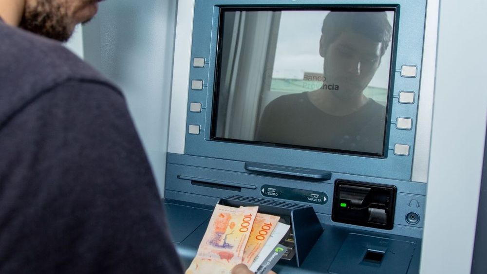 Una persona retira dinero de un cajero.&nbsp;