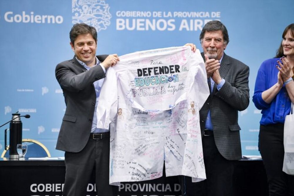 El Gobernador, Axel Kicillof, y el Director General de Cultura y Educación, Alberto Sileoni, en el acto por el Día del Maestro con un guardapolvo blanco con una leyenda significativa, en defensa de la escuela pública. (Gobernación)