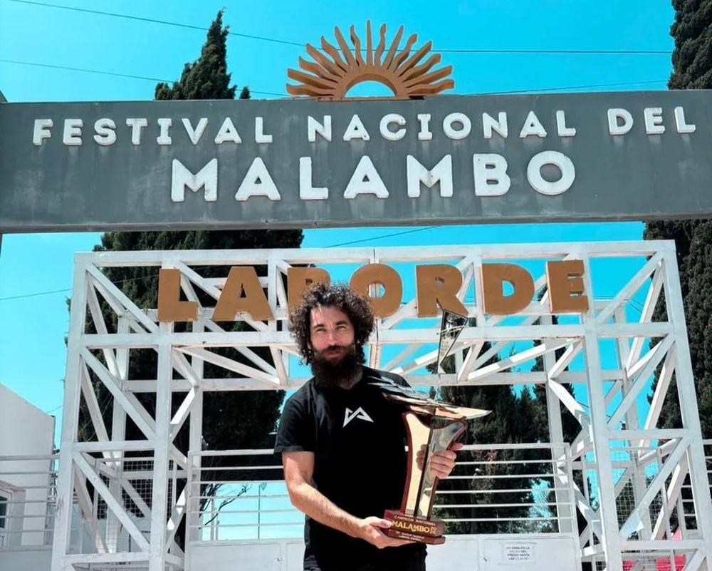 Matías Gallardo exhibe la copa en la entrada del Festival Nacional de Malambo 2026, en la ciudad cordobesa de Laborde.