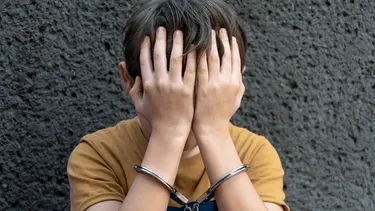 Un niño esposado. Un niño esposado.