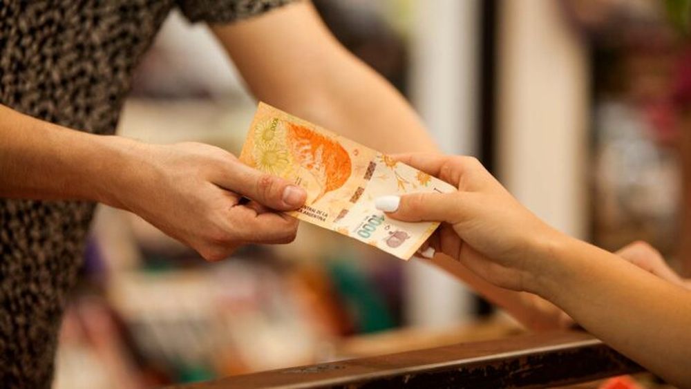 Una persona con un billete en la mano.