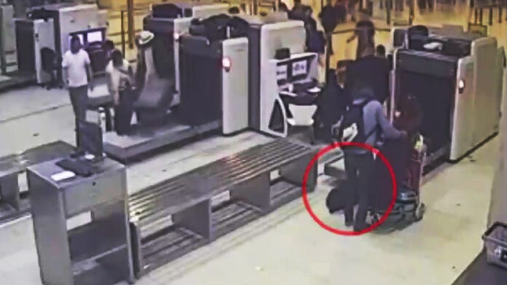 Imagen de las cámaras de la Policía de Seguridad Aeroportuaria (PSA) del momento en el que el polista se lleva la mochila ajena.