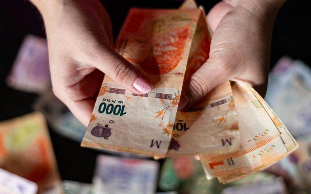 Una persona con pesos argentinos en sus manos.&nbsp;