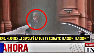 El momento en el que Luis Caputo alza su dedo mayor y le hace el gesto de fuck you a la mujer que lo insultó. (Imagen de TV)