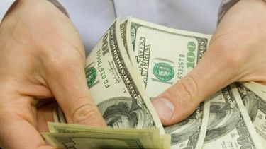 Una persona contando dólares. (Archivo)