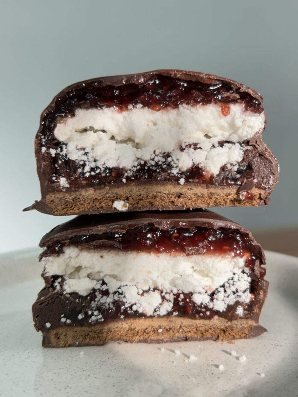 Un alfajor con merengue y cobertura de chocolate.