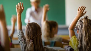 Alumnos y un docente en el aula. 