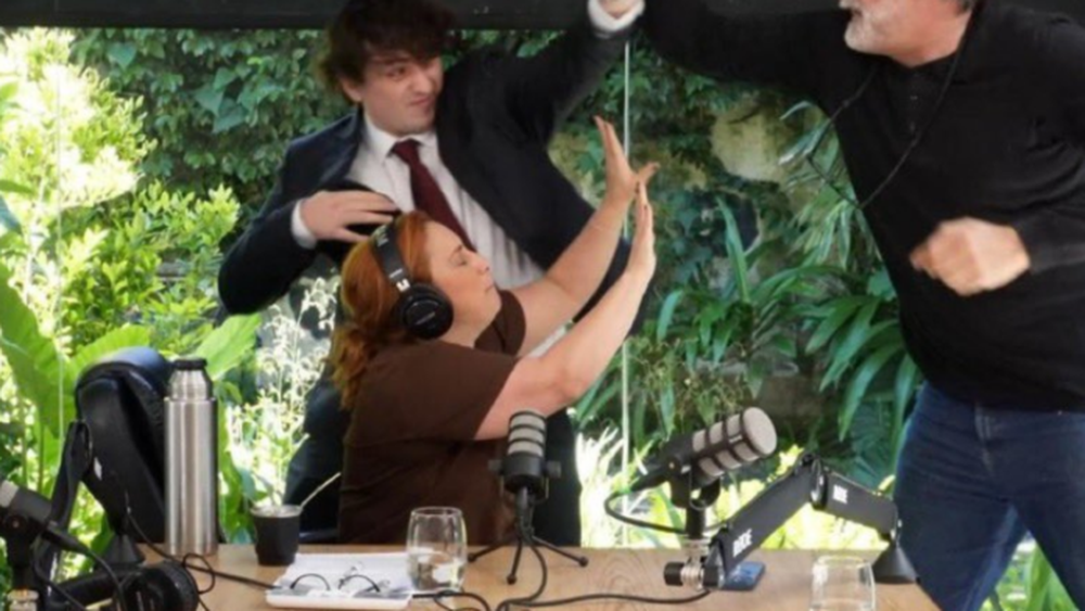 Fran Fijap intenta evitar los golpes de Eduardo Belliboni, en una entrevista en Border Periodismo, con María Julia Oliván.