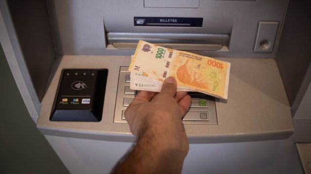 Un hombre retira dinero de una terminal de cajero. (Xinhua)