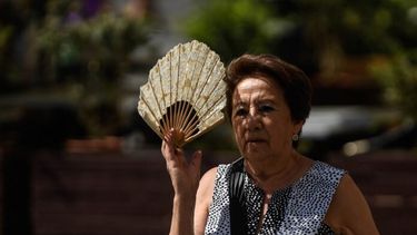 Una mujer se protege del sol con un abanico. (Xinhua)