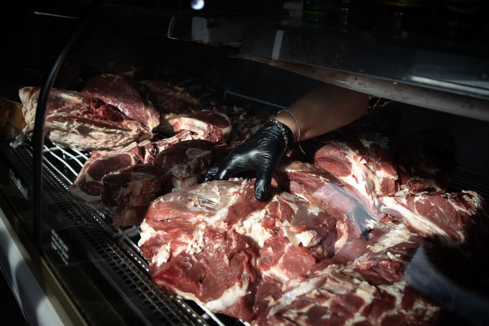 Una trabajadora acomoda una pieza de carne vacuna en una carnicería. (Agencia Xinhua)