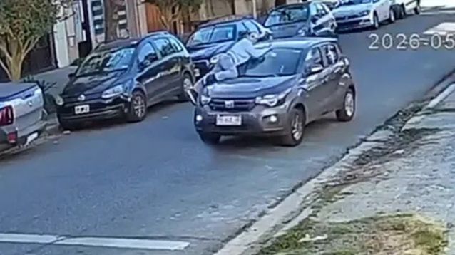 El momento en el que la mujer se sube al capot de su auto.