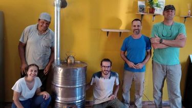 Los creadores del proyecto y voluntarios junto a una de las estufas ecológicas instalada en una casa. (UNS)