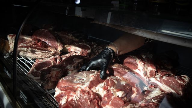 Una trabajadora acomoda una pieza de carne vacuna en una carnicería. (Agencia Xinhua)