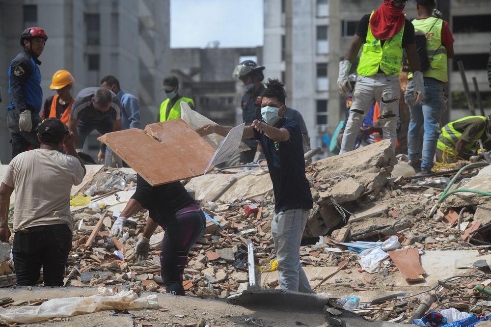 Personas remueven escombros de un edificio derrumbado luego de los terremotos en Venezuela. (Xinhua/Marcos Salgado)&nbsp;