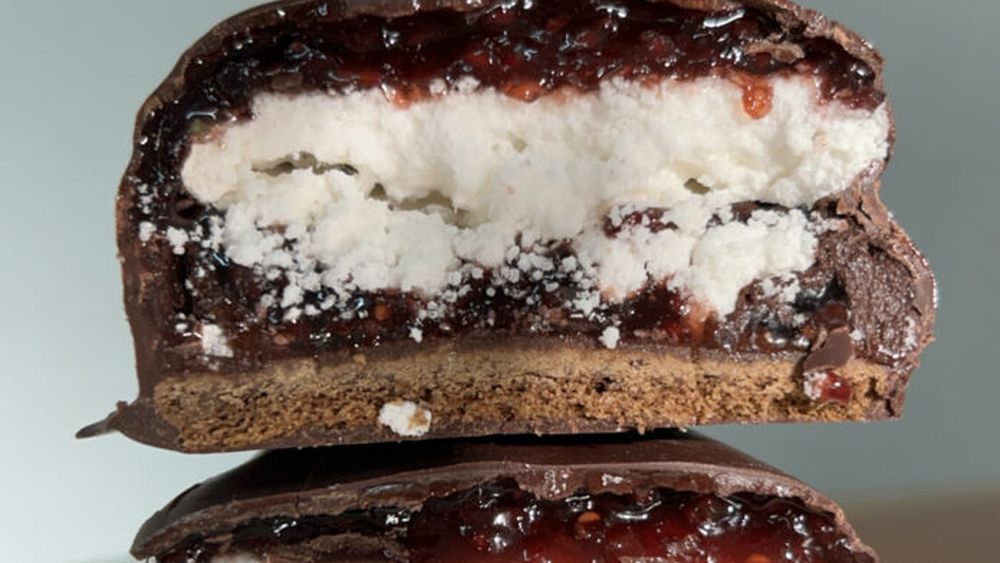Un alfajor con merengue y cobertura de chocolate.