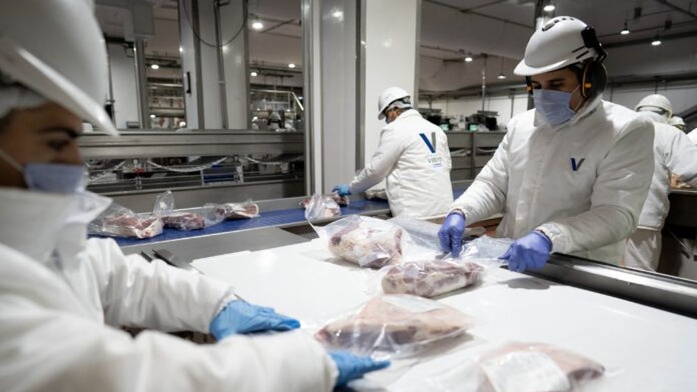 Trabajadores envasando al vacío piezas de carne. (Xinhua/Martín Zabala)