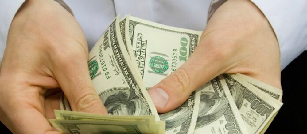 Una persona contando dólares. (Archivo)