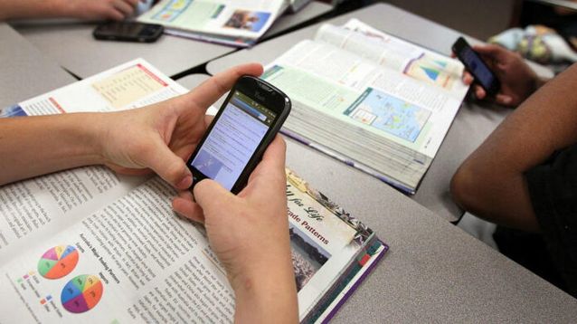 Alumnos usando teléfonos celulares.
