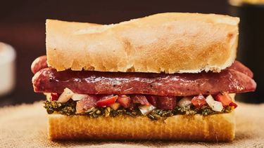 La fórmula clásica del choripán: una rodaja de pan francés bien fresco, chori mariposa, chimichurri y otra rodaja de pan francés