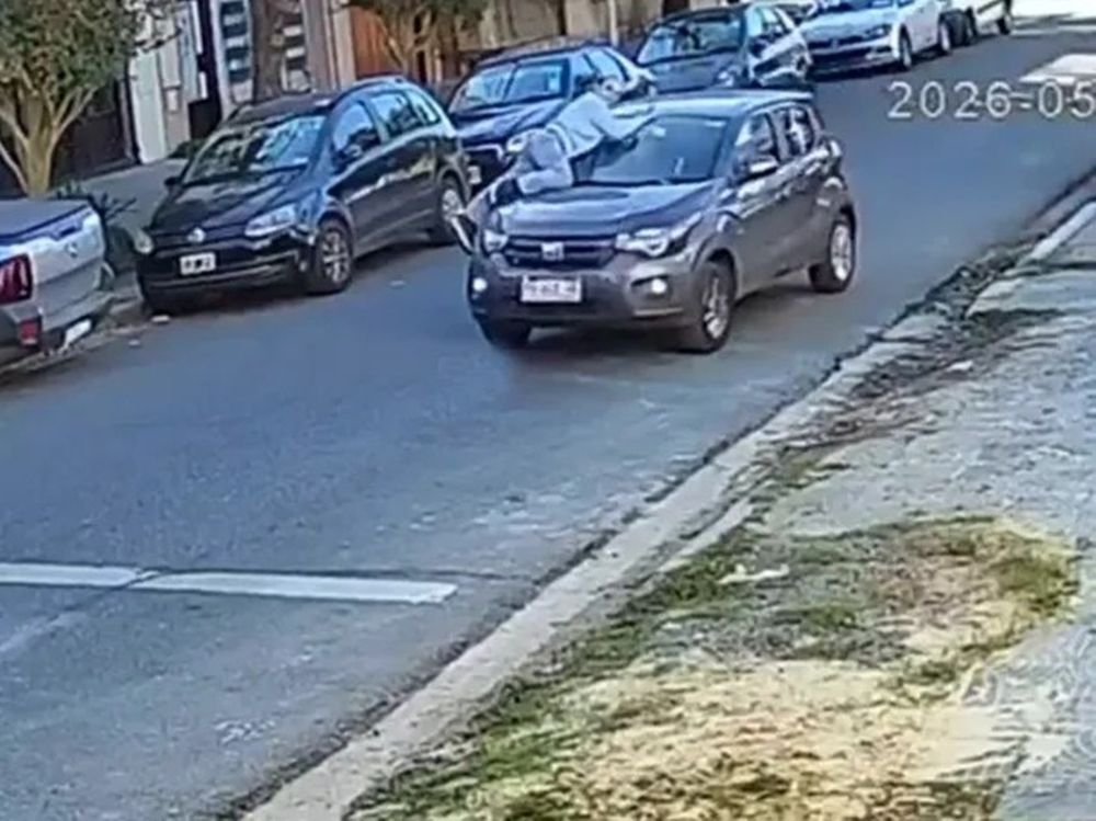 El momento en el que la mujer se sube al capot de su auto.