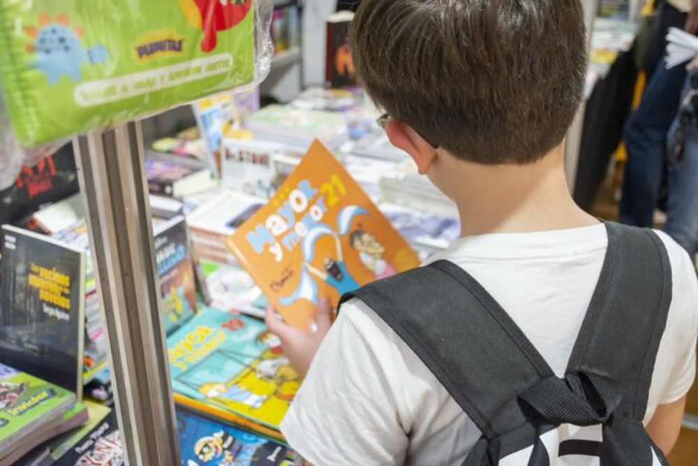 Un niño con un libro en una feria.