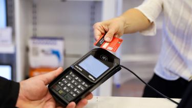 Una persona haciendo un pago con tarjeta.