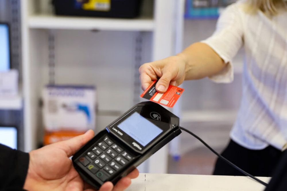 Una persona haciendo un pago con tarjeta.