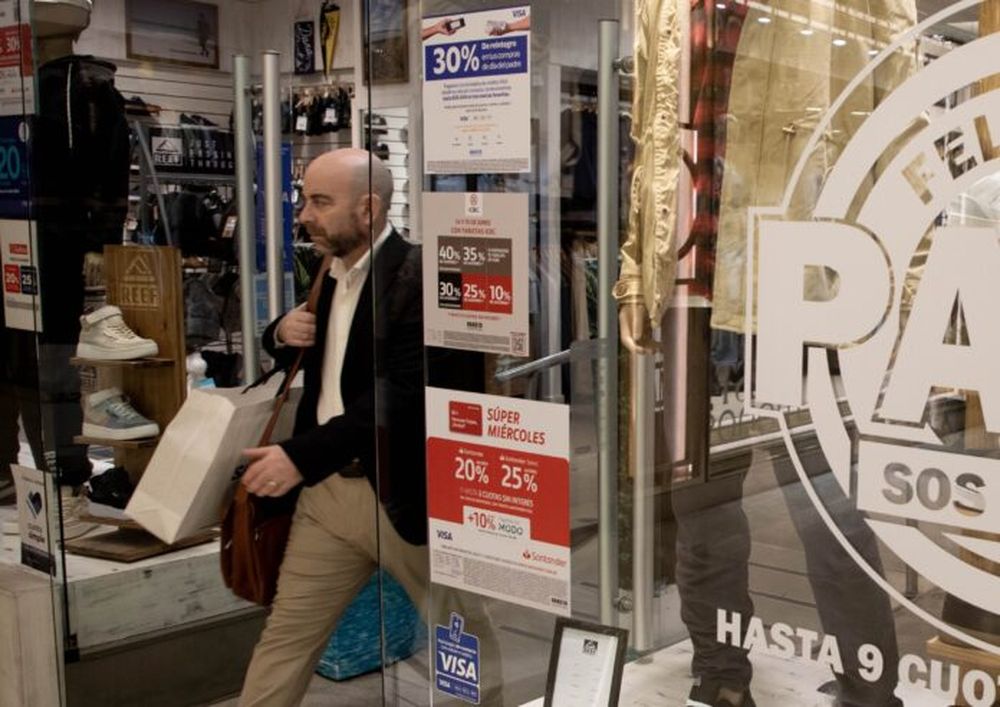 Un hombre saliendo de un local de venta de ropa masculina (Xinhua/Martín Zabala)