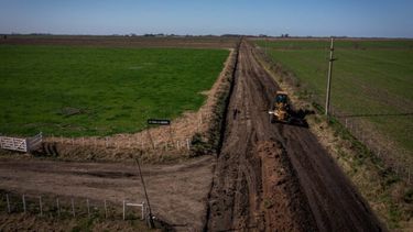 Una máquina trabajando en un camino rural.
