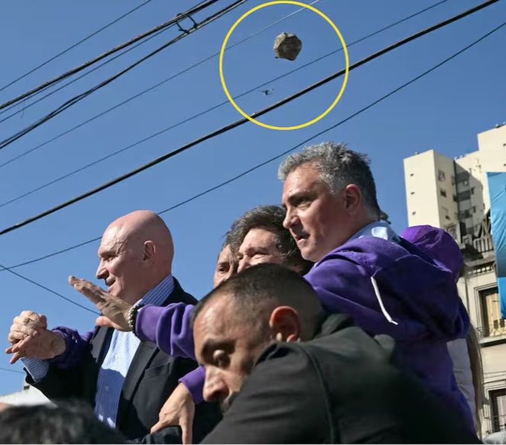Milei, con Espert y Parejas, en Lomas,enel momento en que una piedra vuela sobre sus cabezas.&nbsp;