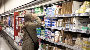 Una mujer observa los precios de productos lácteos en un supermercado. (Xinhua/Martín Zabala)