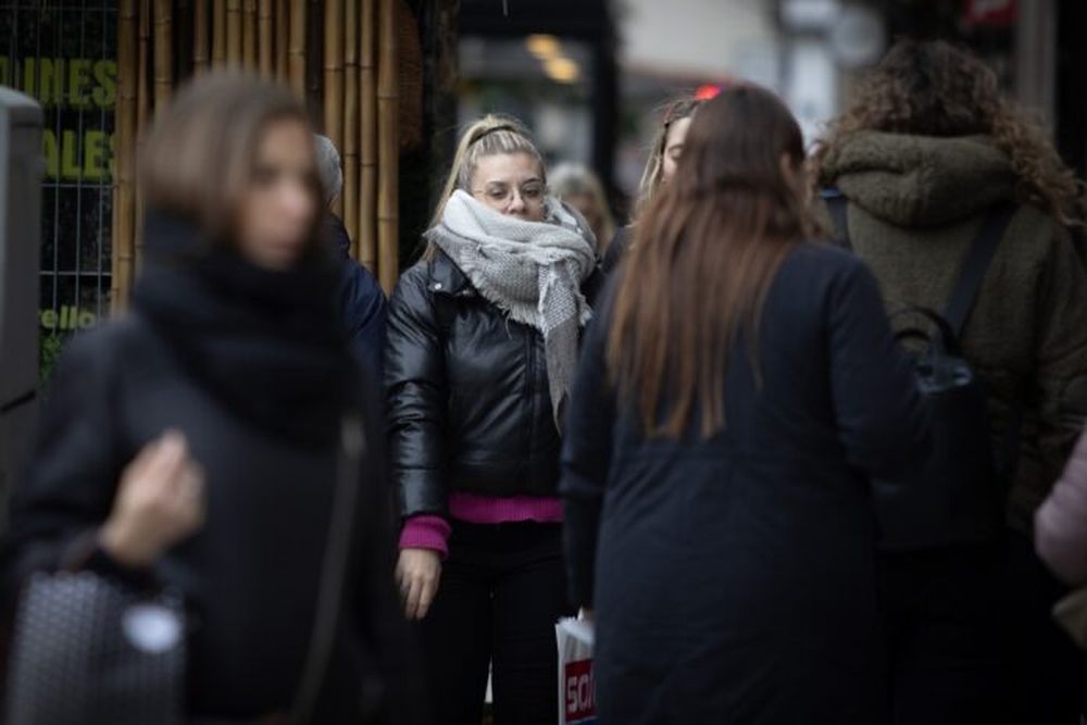 Personas portan ropa abrigadora mientras caminan por una calle durante una ola de frío. (Xinhua/Martín Zabala)