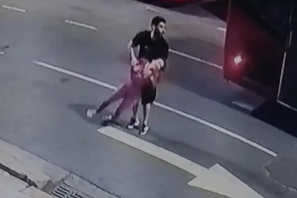 Facundo Moyano sostiene a su pareja, que salió semidesnuda a la calle en un presunto ataque de pánico.