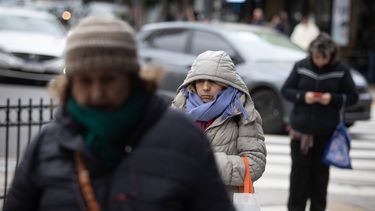 Personas portan ropa abrigadora mientras caminan por una calle. (Agencia Xinhua)